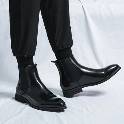 Black cap-toe Chelsea boots worn with black trousers