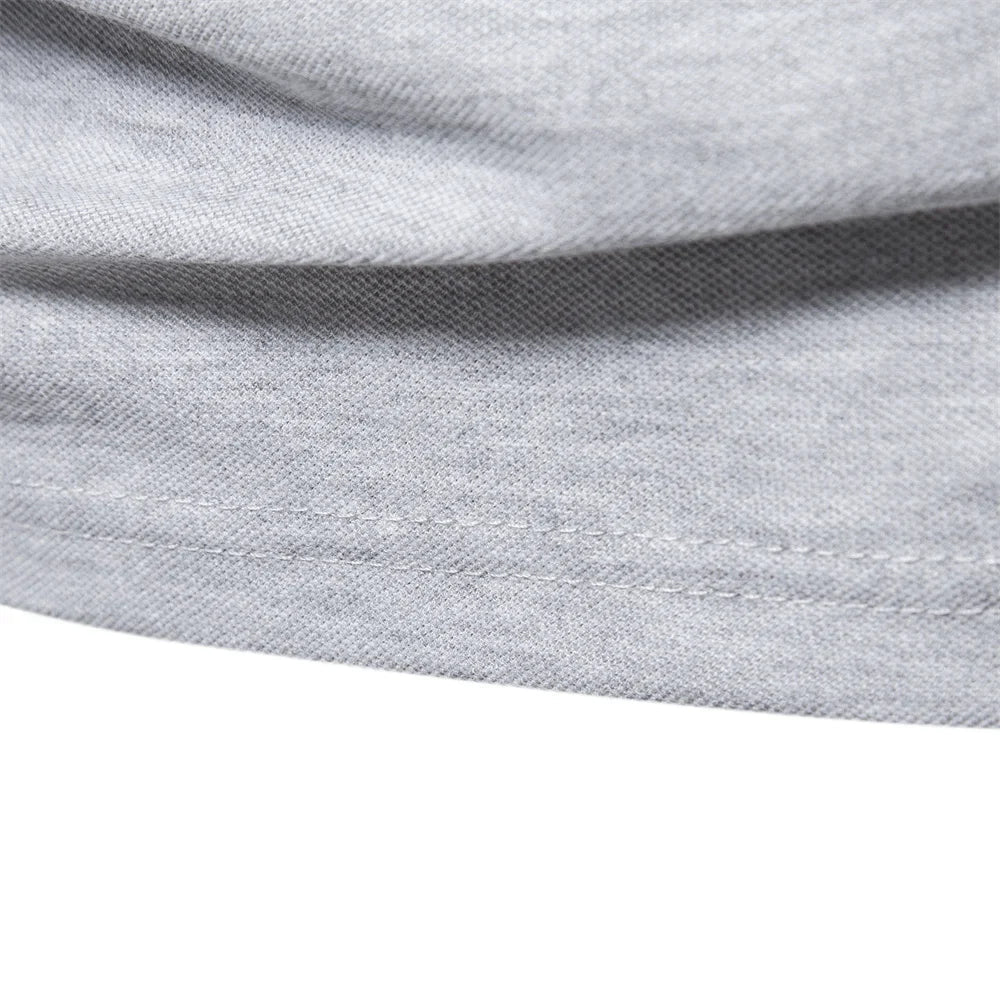 Close-up of the stitched hem on the gray polo shirt