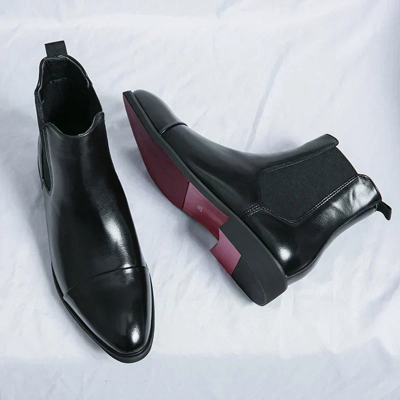 Black Chelsea boot seen from above beside a boot lying on its side