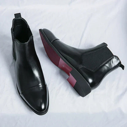 Black Chelsea boot seen from above beside a boot lying on its side