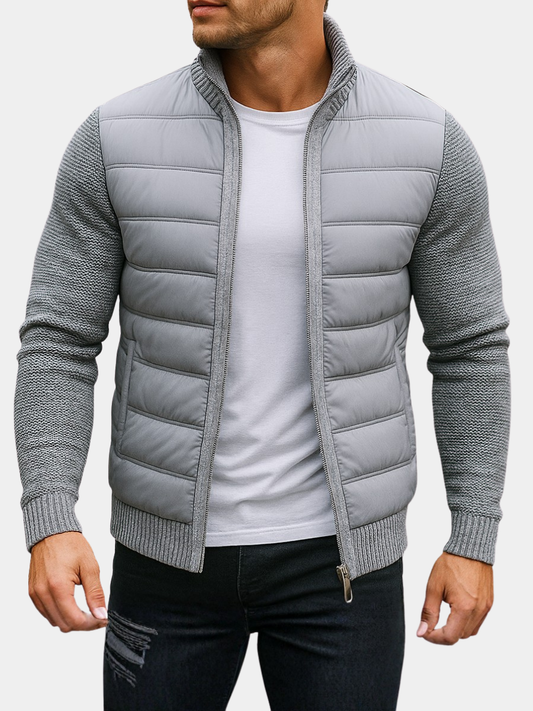 Man wearing a light gray quilted hybrid jacket with knit sleeves, front view