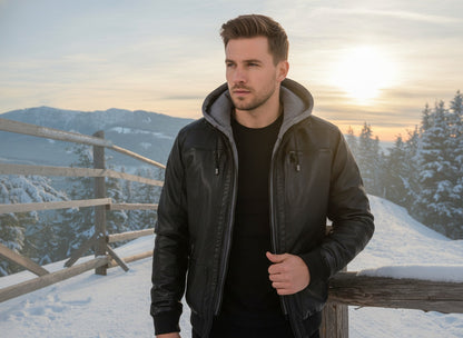 Man wearing a black leather jacket with grey hood in the snow